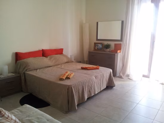 Zona notte di una camera del B & B Roma Bellaventura con cuscini e comodino